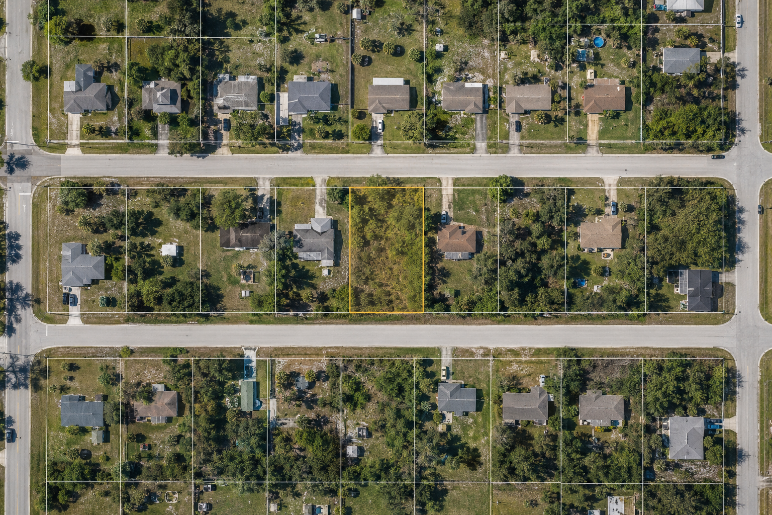 Straight-down aerial view of a vacant infill lot among Palm Bay homes with illustrative parcel boundaries